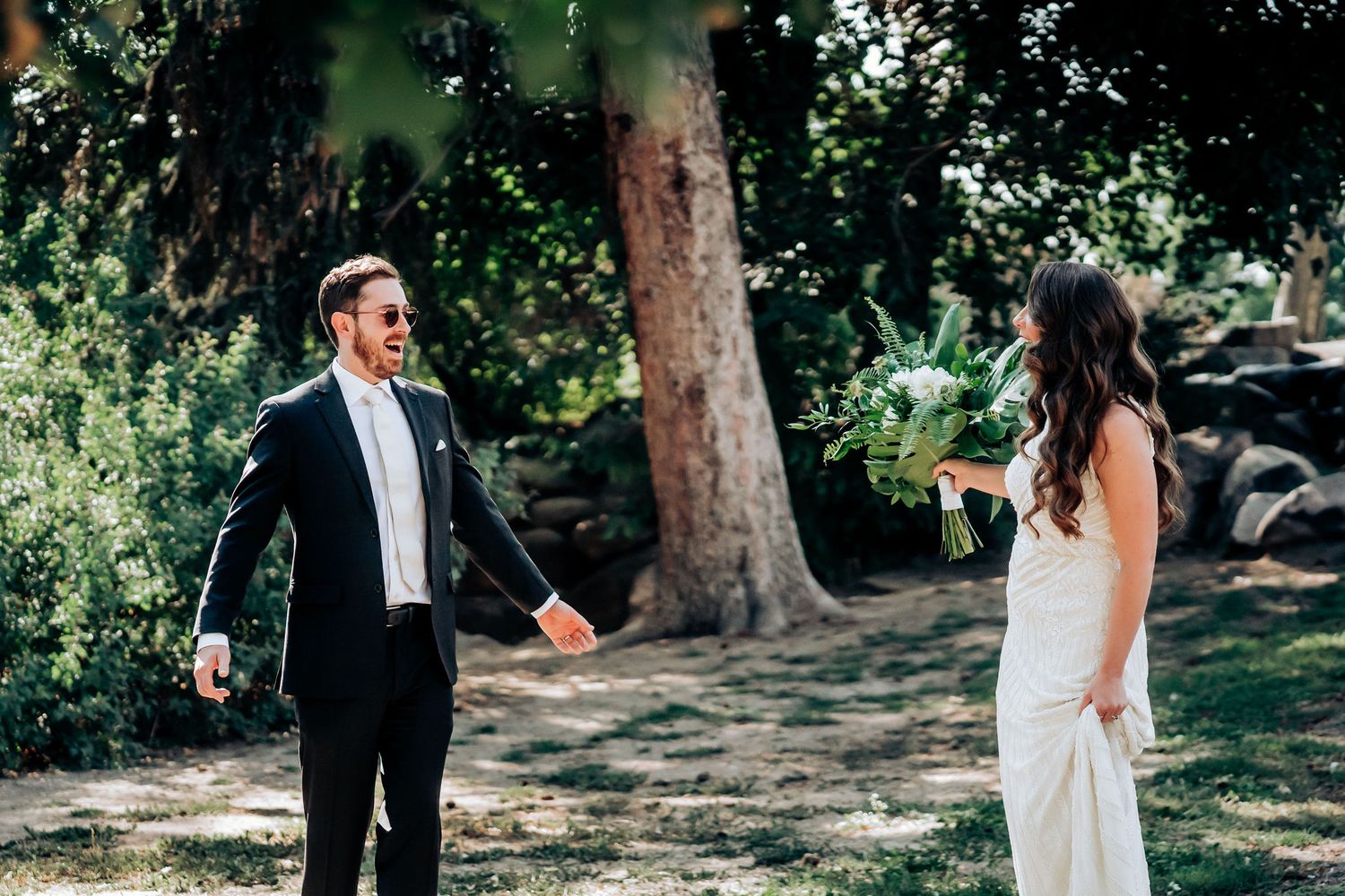 A joyful wedding moment captured between a couple in an outdoor garden setting.