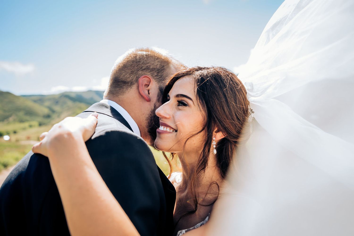 Romantic wedding couple sharing an intimate moment against a scenic mountain backdrop.