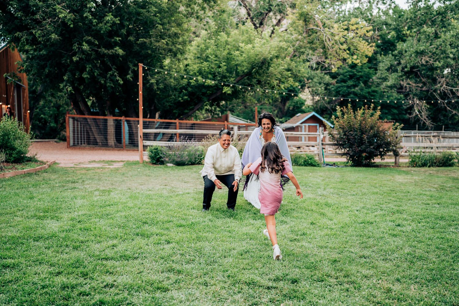 Playful celebration on a grassy lawn with playground equipment visible in the background.