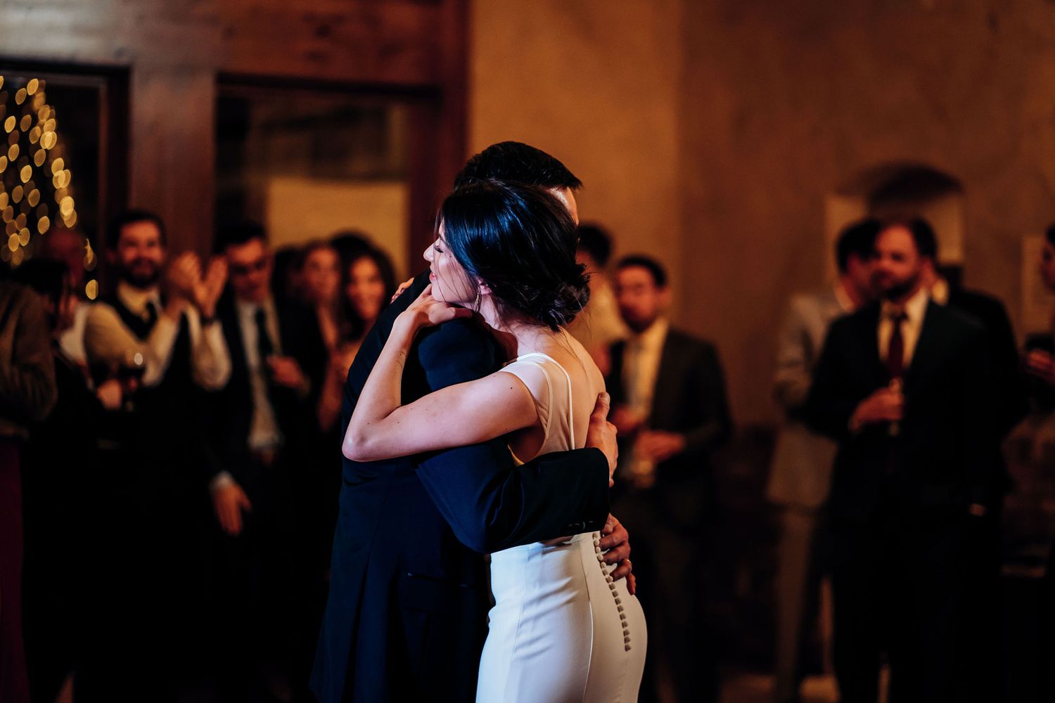 Two dancers share a moment during a traditional dance on a wooden ballroom floor.
