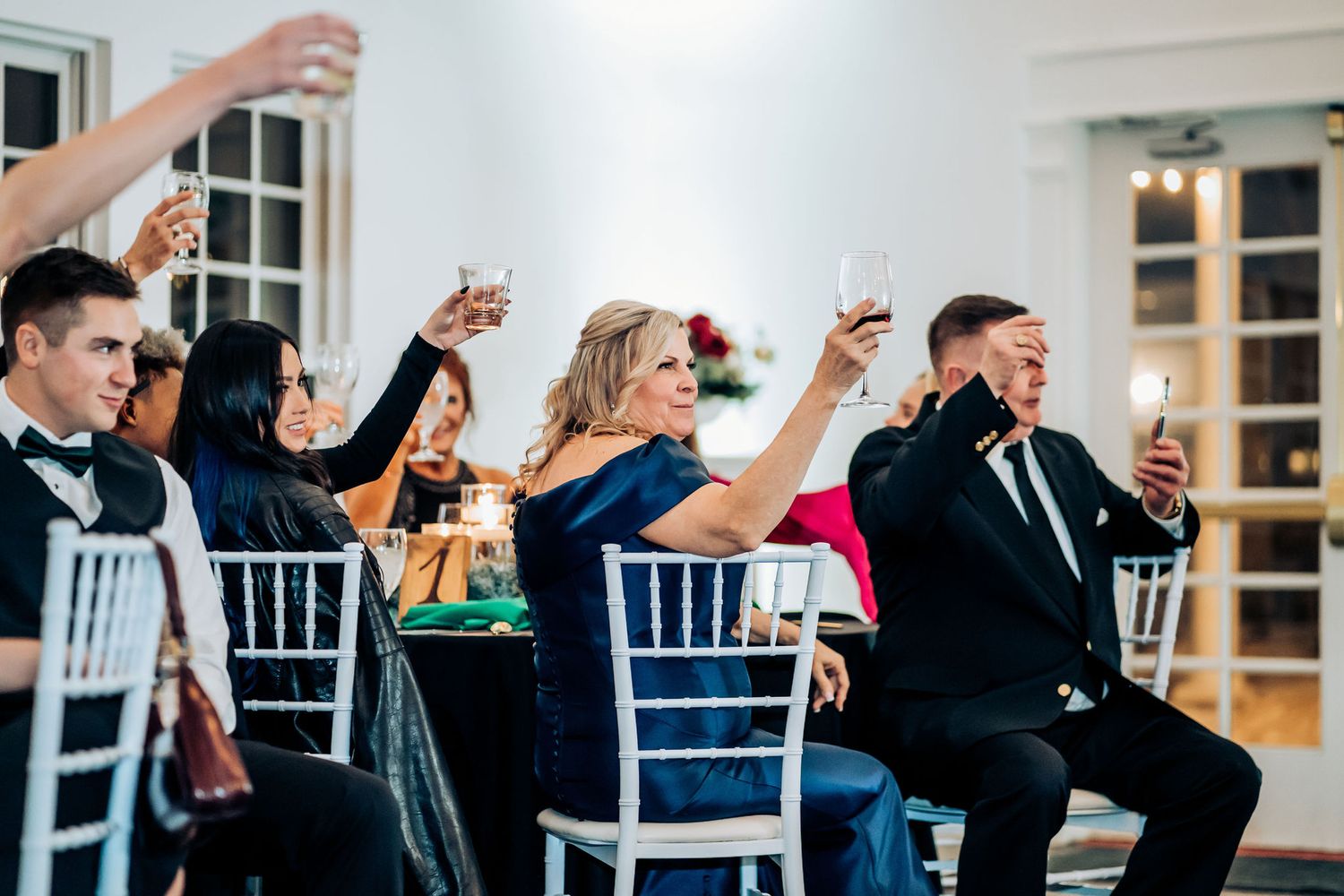 Guests enjoying a celebratory moment during a wedding reception in a bright indoor venue.