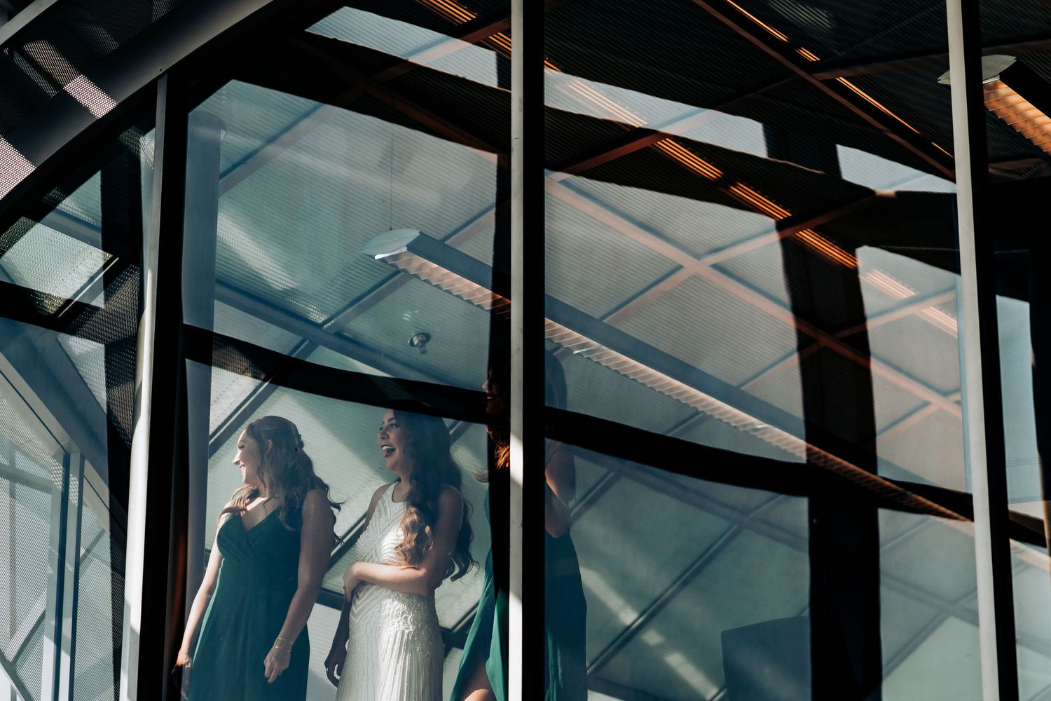 Artistic architectural shot of people through geometric glass windows and metal beams.