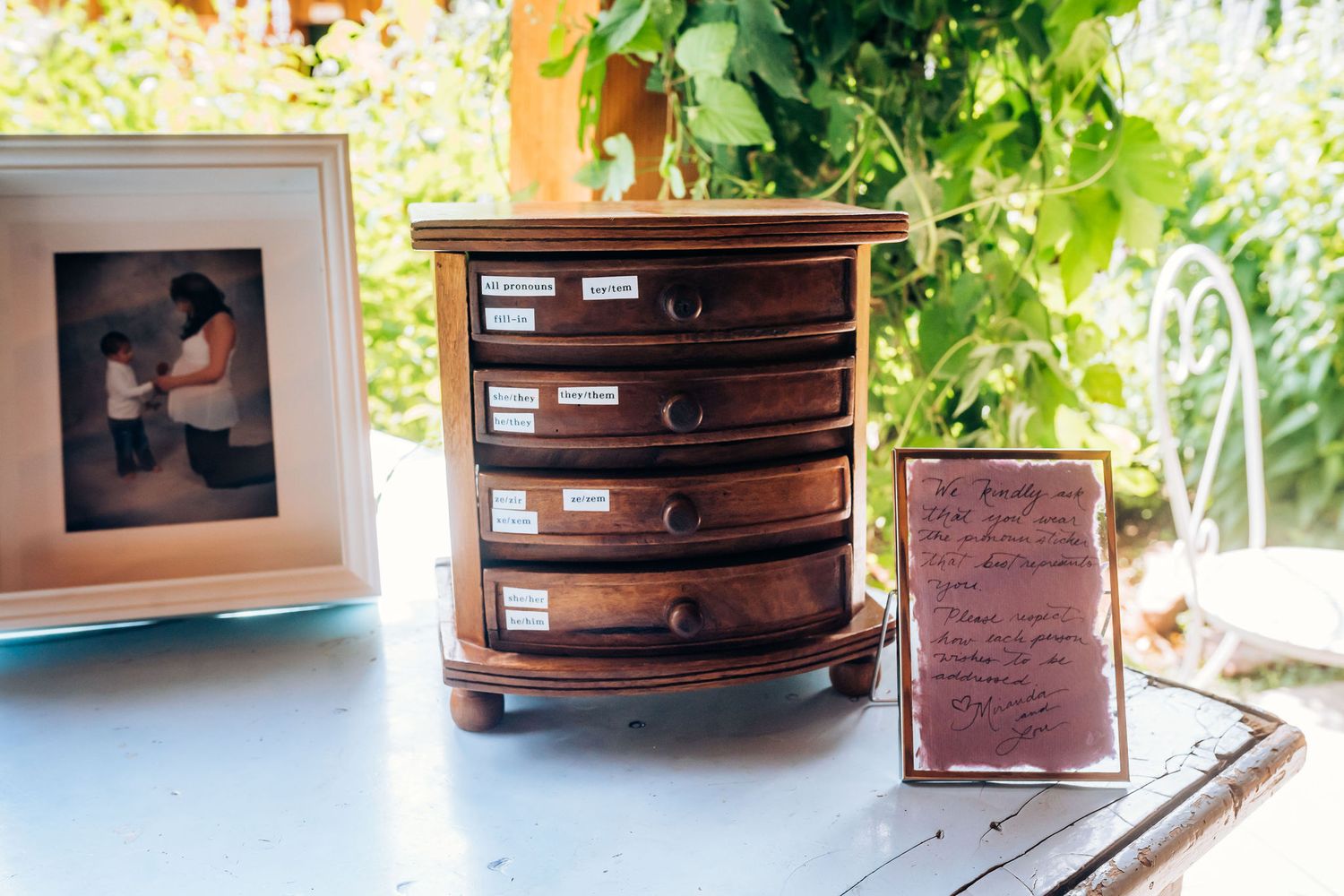 Vintage wooden jewelry box and framed photographs arranged on blue surface.