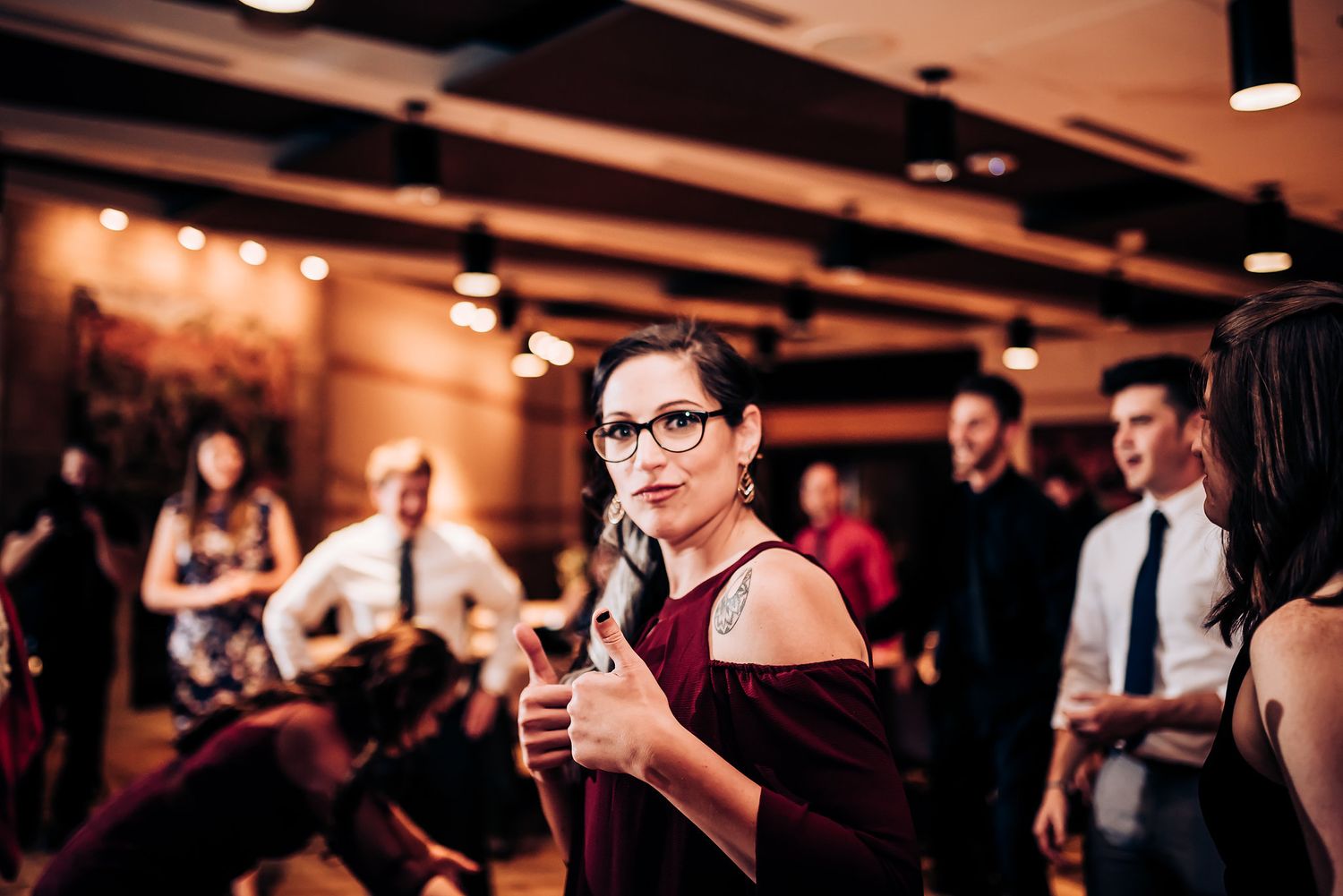 Event celebration in warmly lit indoor venue with crowd in formal attire.