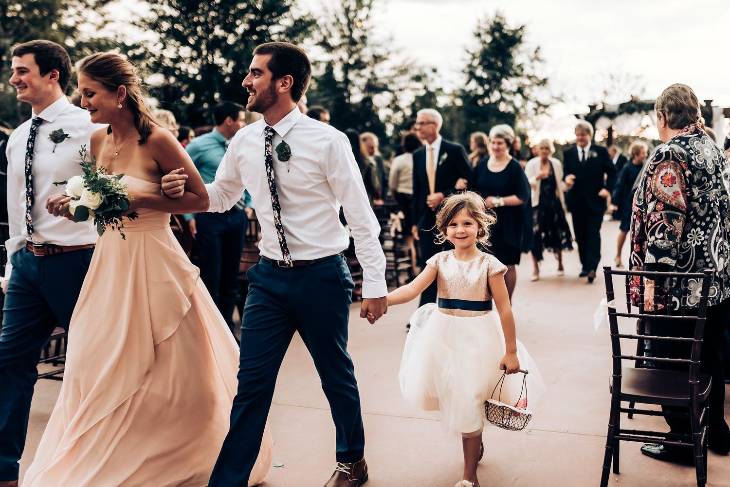 Wedding guests dance joyfully on an outdoor dance floor during the reception celebration.