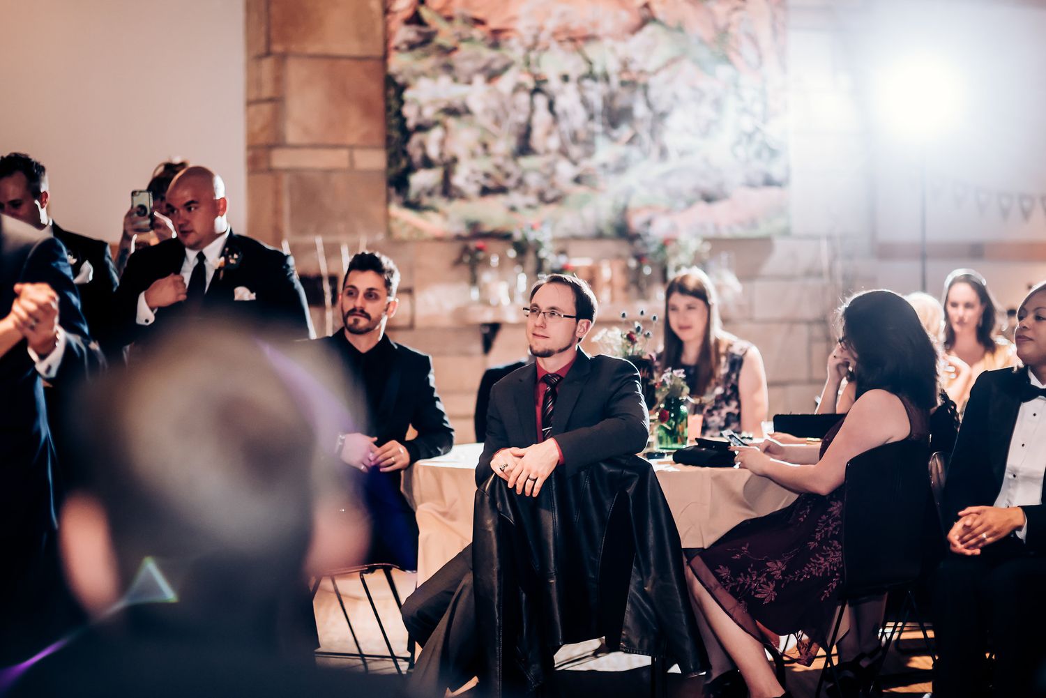 Wedding guests dressed in formal attire enjoy the reception celebration.