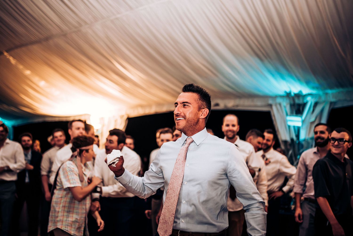 Guest leading a celebratory dance moment at a wedding reception.
