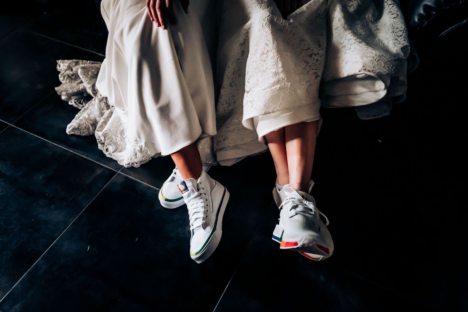 White wedding dresses and casual sneakers shown in artistic detail shot.