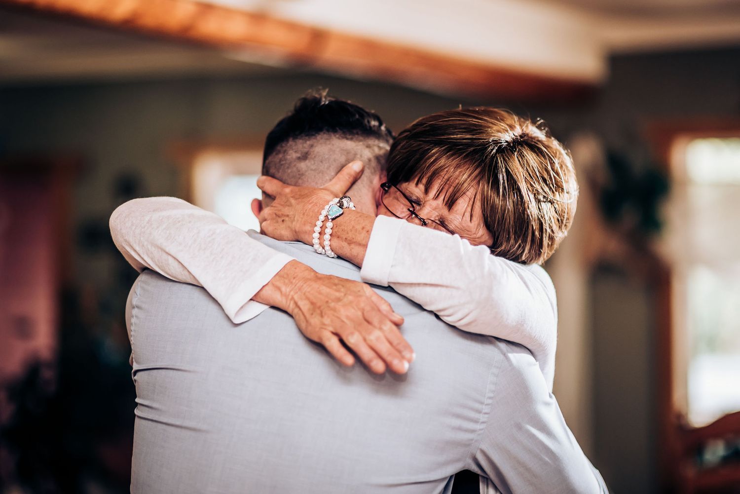 Two people embrace emotionally during a special moment at an indoor event.
