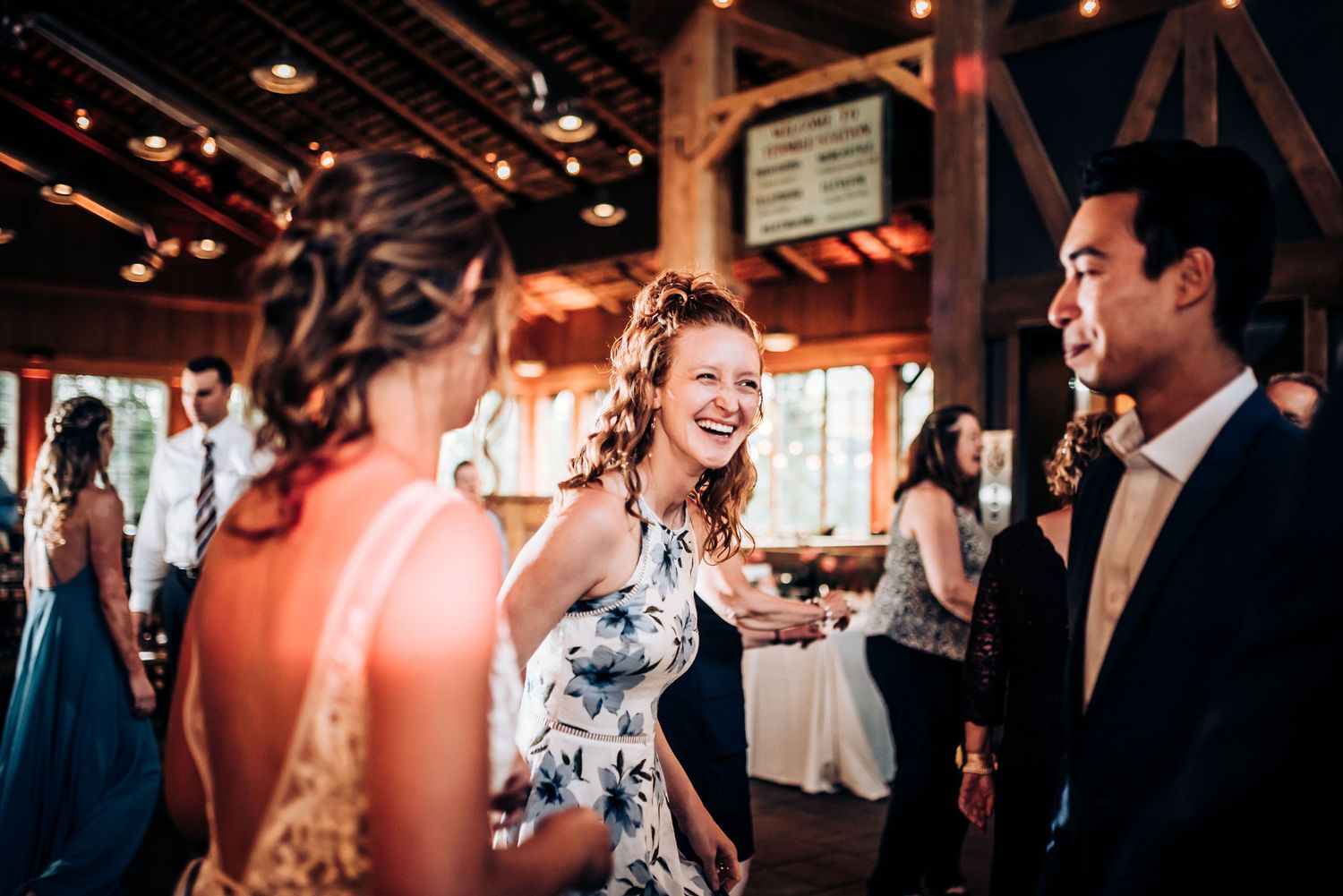 Wedding guests enjoying themselves on the dance floor at a rustic reception venue.