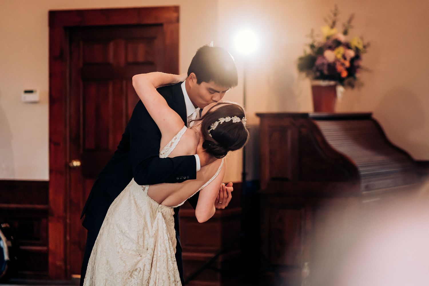 A romantic dip during a wedding dance in an elegantly decorated venue.