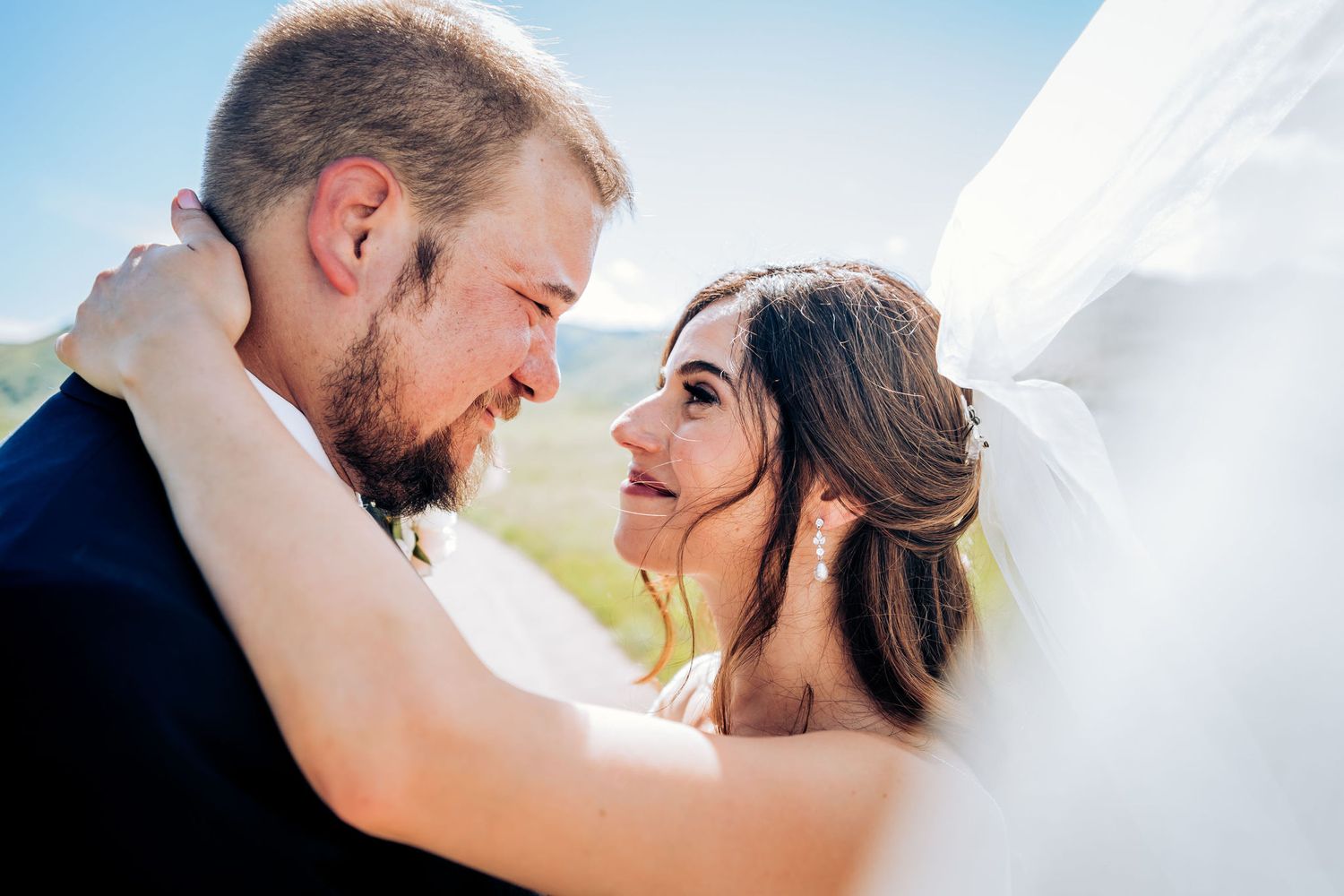 A tender moment between newlyweds against a mountain backdrop.