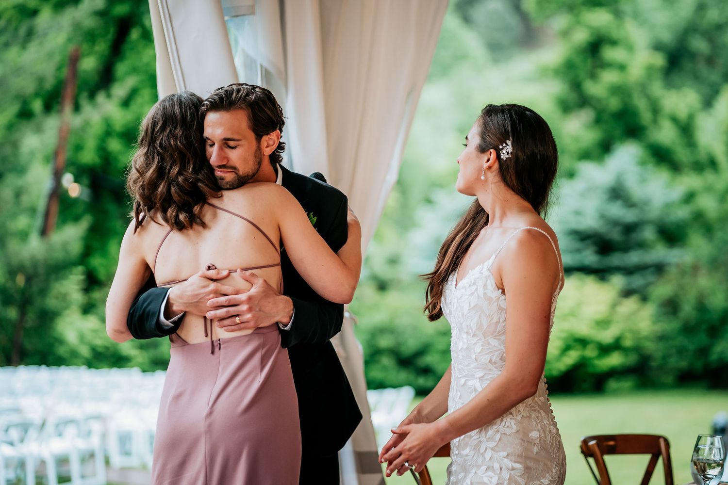 An emotional moment during a wedding reception as attendants share embraces.