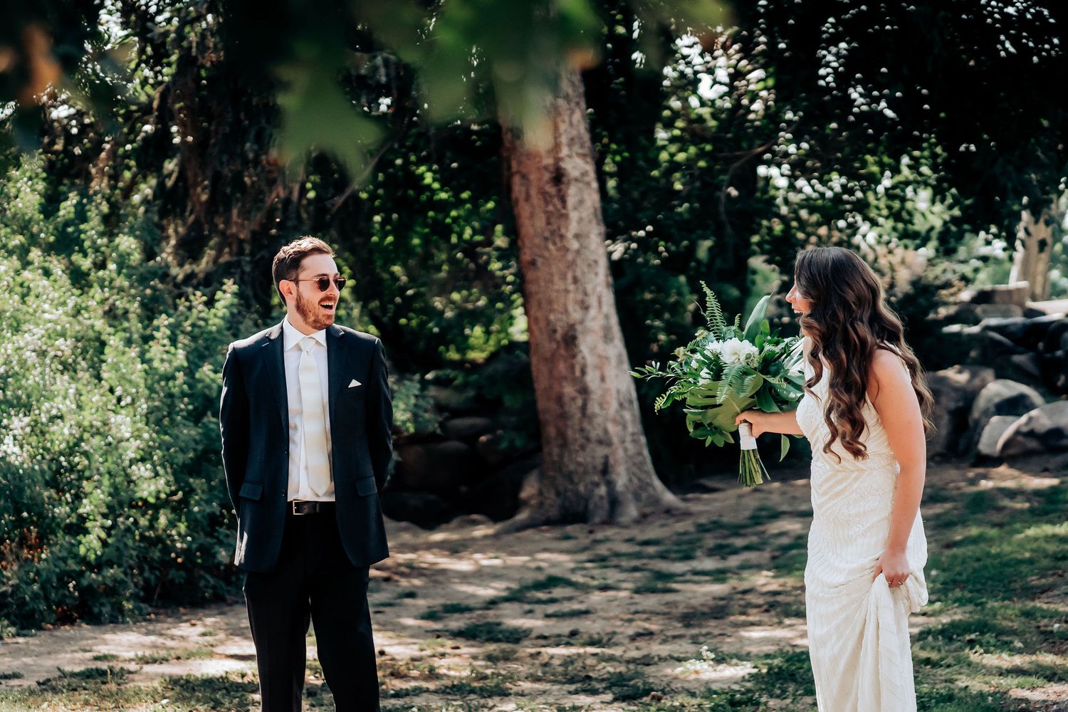 A couple enjoying their first look on their wedding day in a natural outdoor setting.