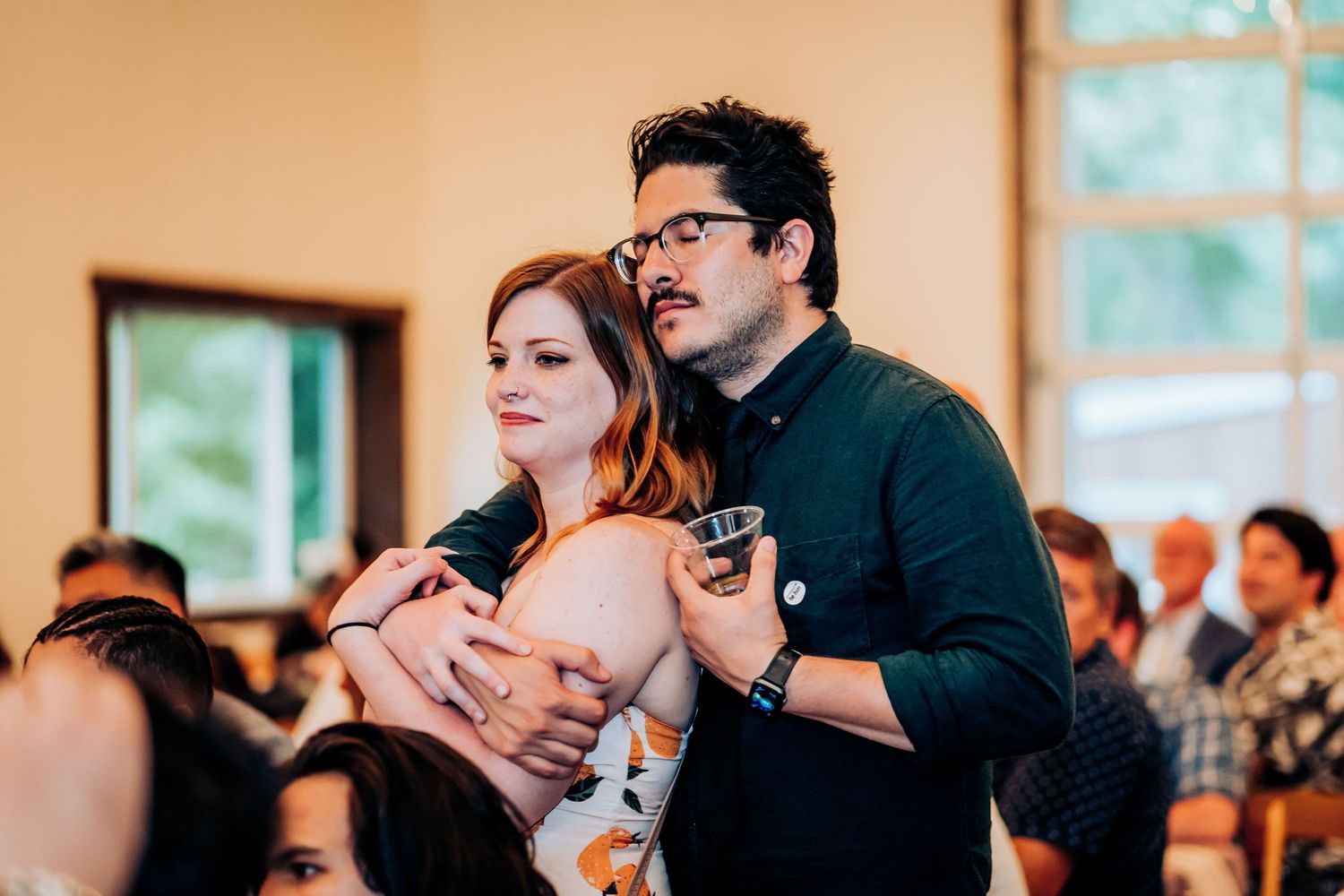 A couple embraces on the dance floor during an indoor wedding celebration.