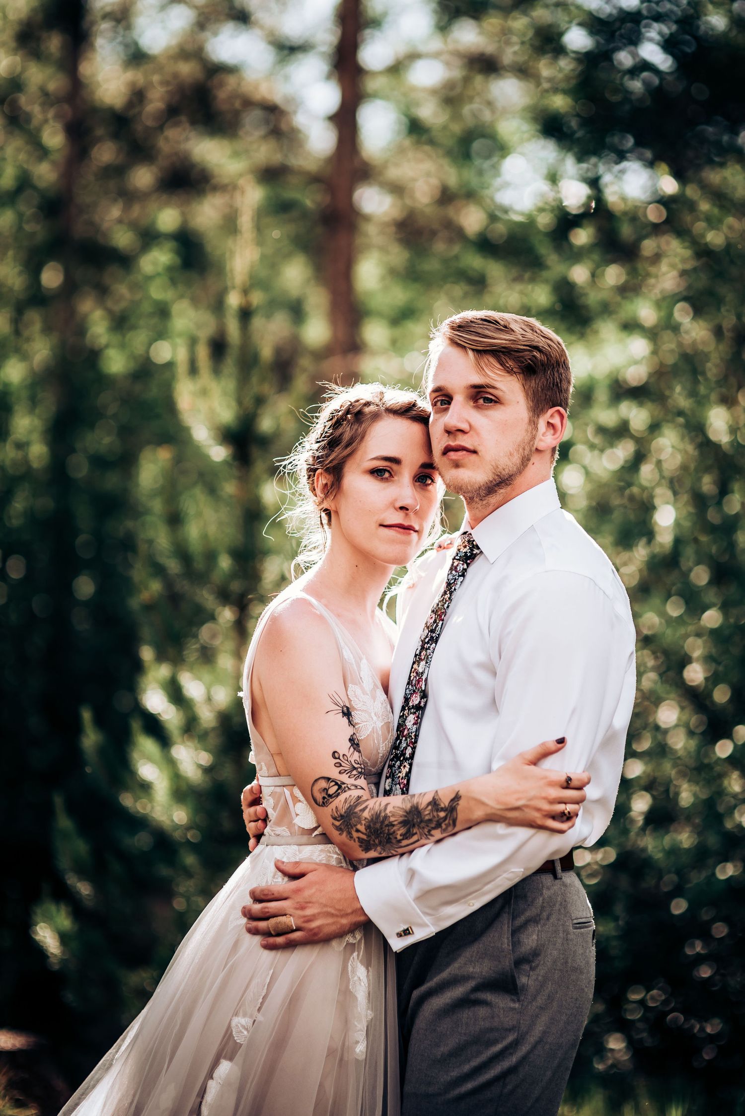 A dreamy forest portrait showcasing a champagne wedding dress and delicate tattoo details.