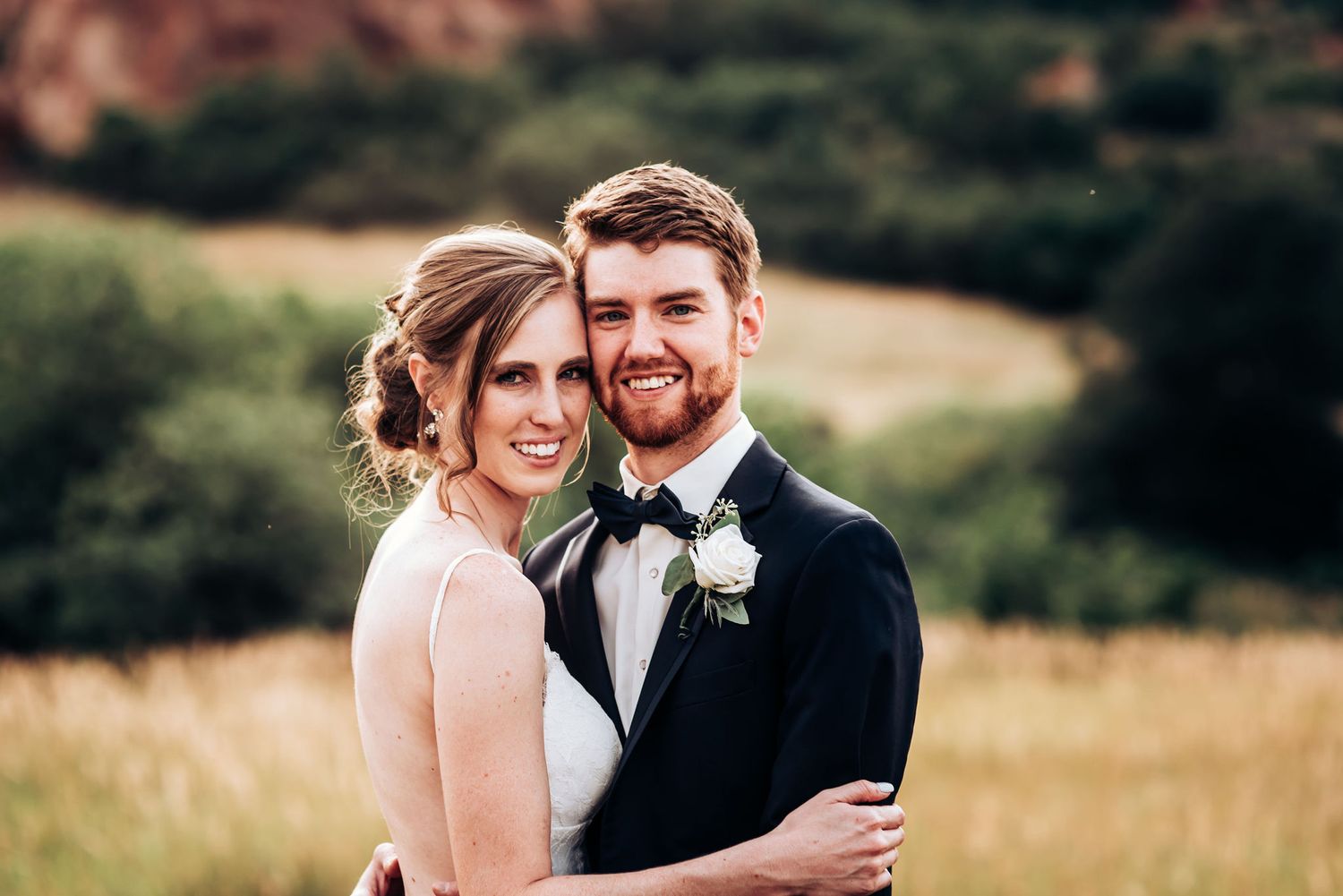 Elegant wedding portrait with dramatic red rock formations in background.