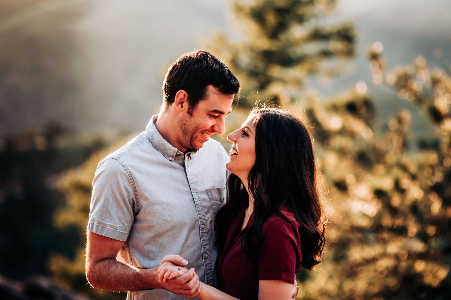 Joyful moment shared between couple during mountain engagement photoshoot.