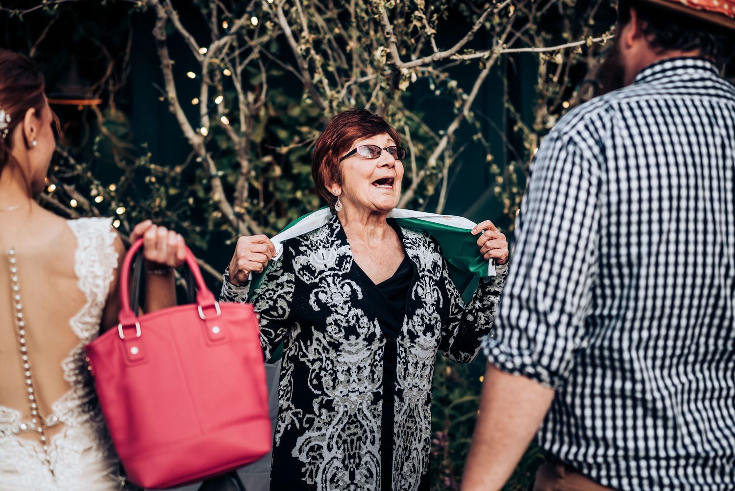 Candid moment at outdoor gathering with pink handbag visible.