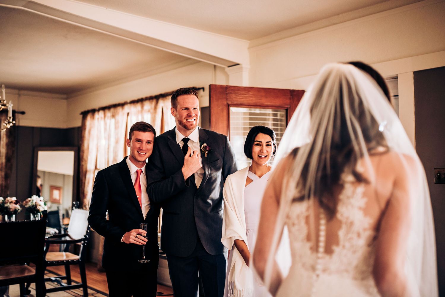 Wedding celebration moment captured indoors with guests sharing laughter and drinks.