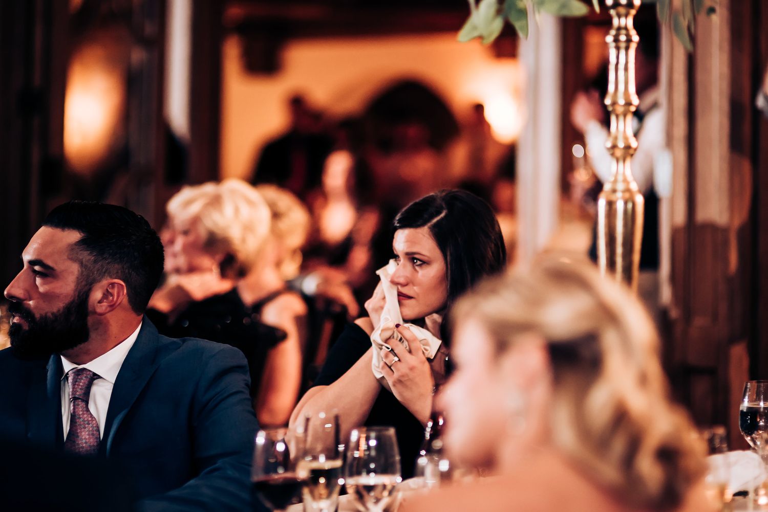 Emotional reactions captured during wedding reception speeches at an elegant evening celebration.