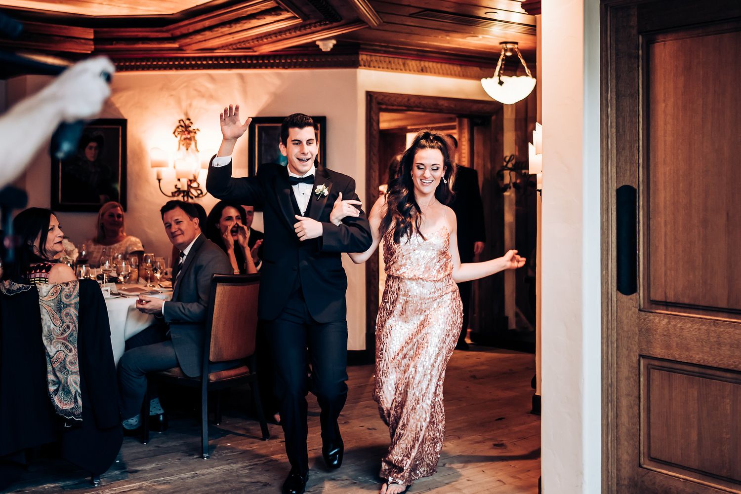 Celebration entrance into a reception hall with warm wooden ceiling and chandelier lighting.