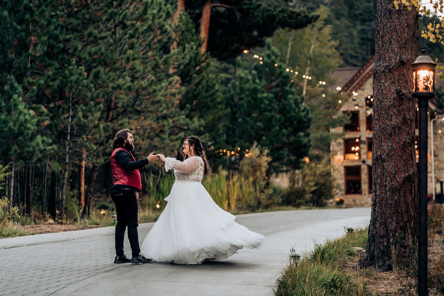 Wedding party celebration outside rustic venue with string lights.