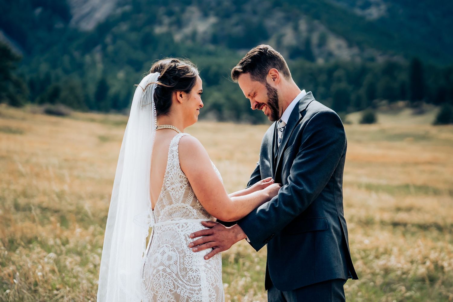 Couple sharing emotional moment during outdoor mountain wedding ceremony.
