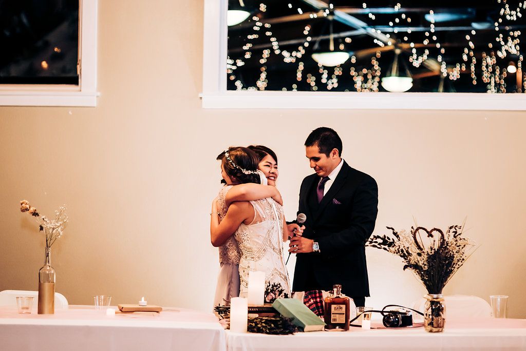 Couple cuts their wedding cake together at an elegant indoor reception.