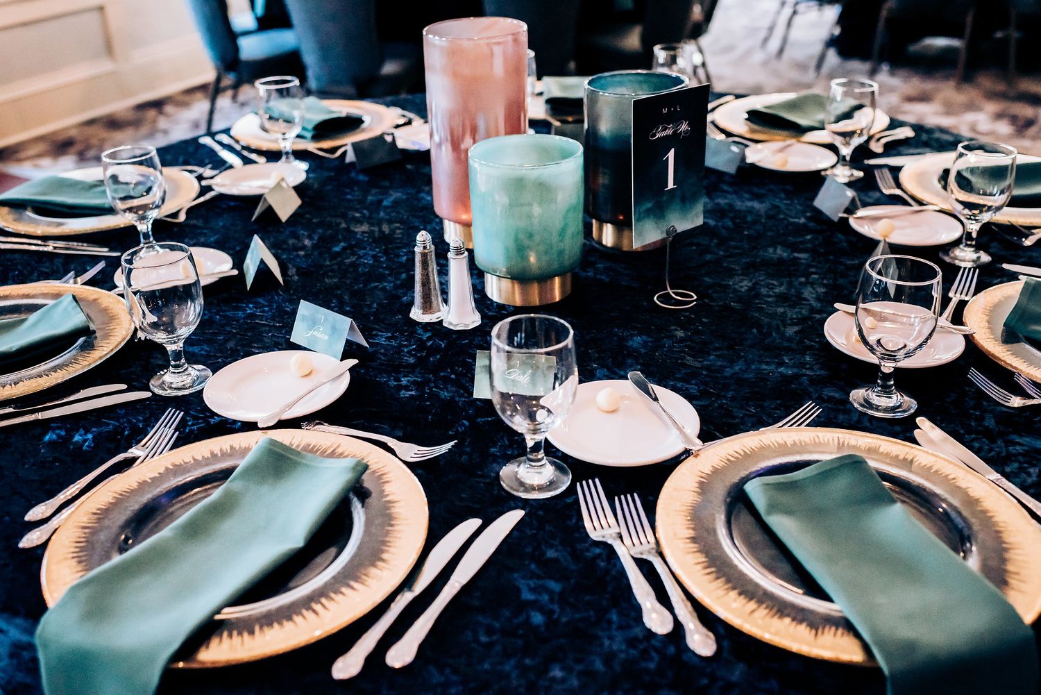 Elegant table setting with navy linens, mint napkins and gold charger plates.