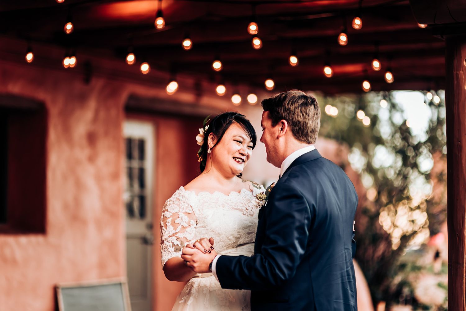 Candid wedding moment captured on rustic terrace with warm lighting.