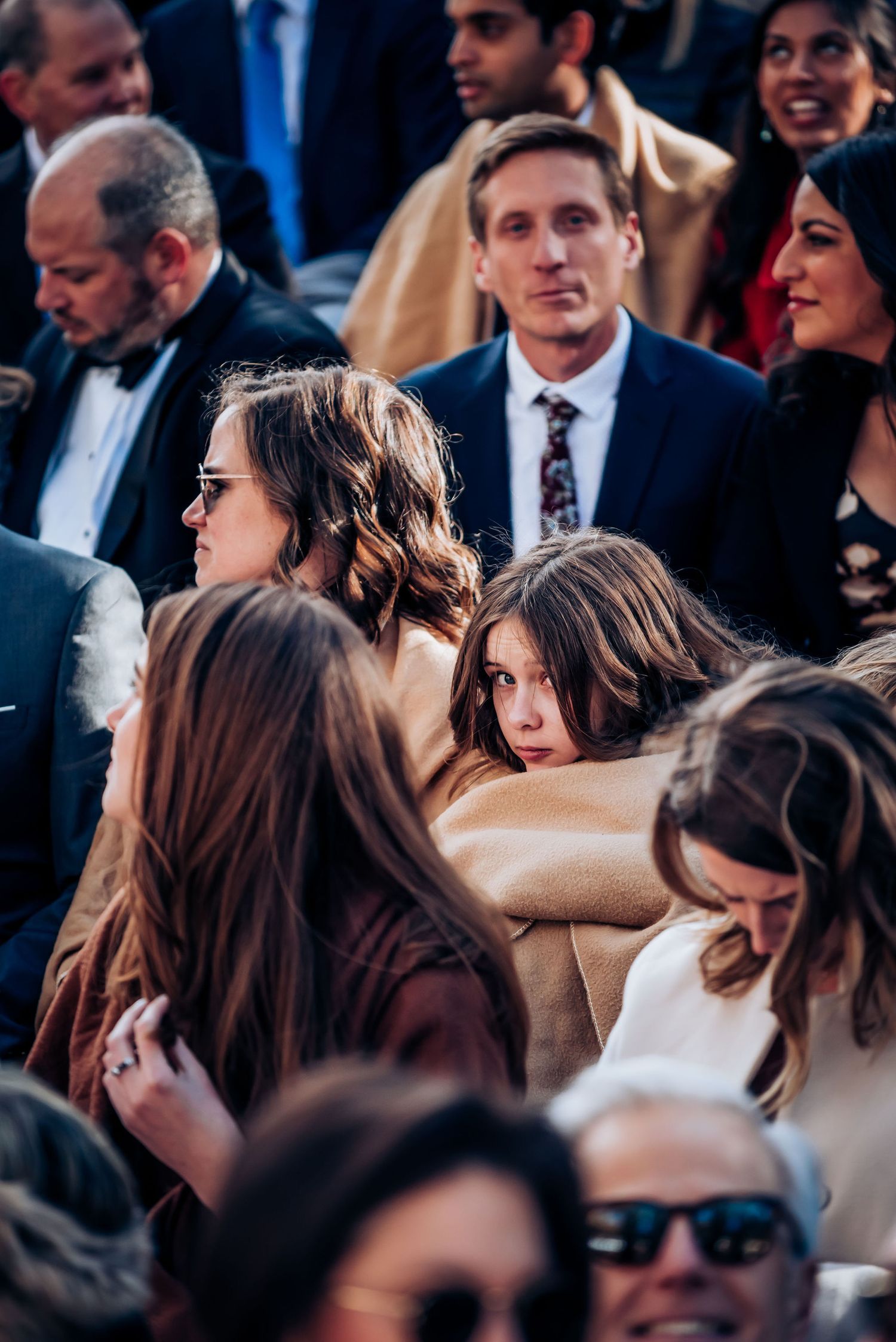Wedding guests filling rows of seats at an outdoor mountain celebration.