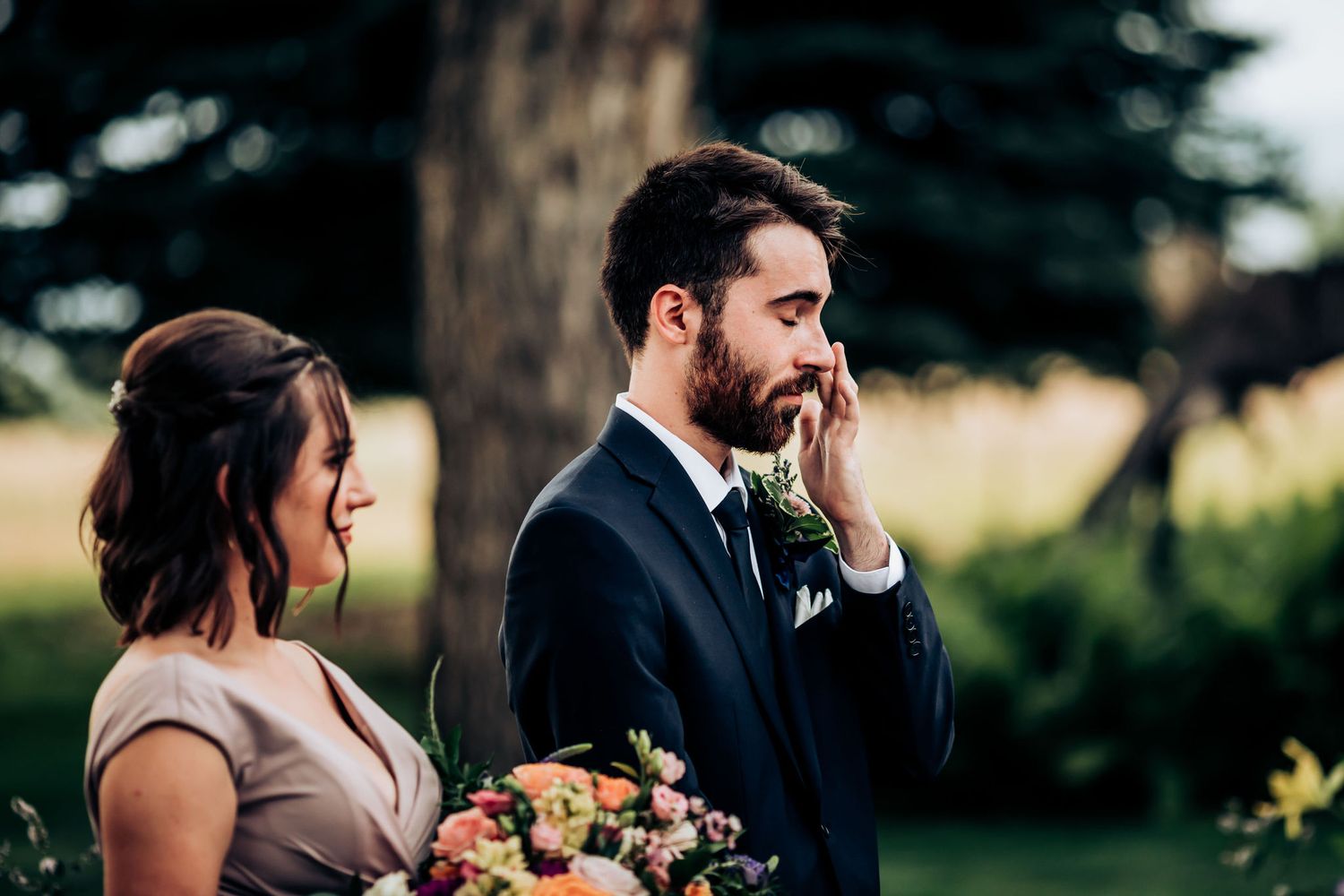 Emotional moment during outdoor wedding ceremony with mountain landscape in background.