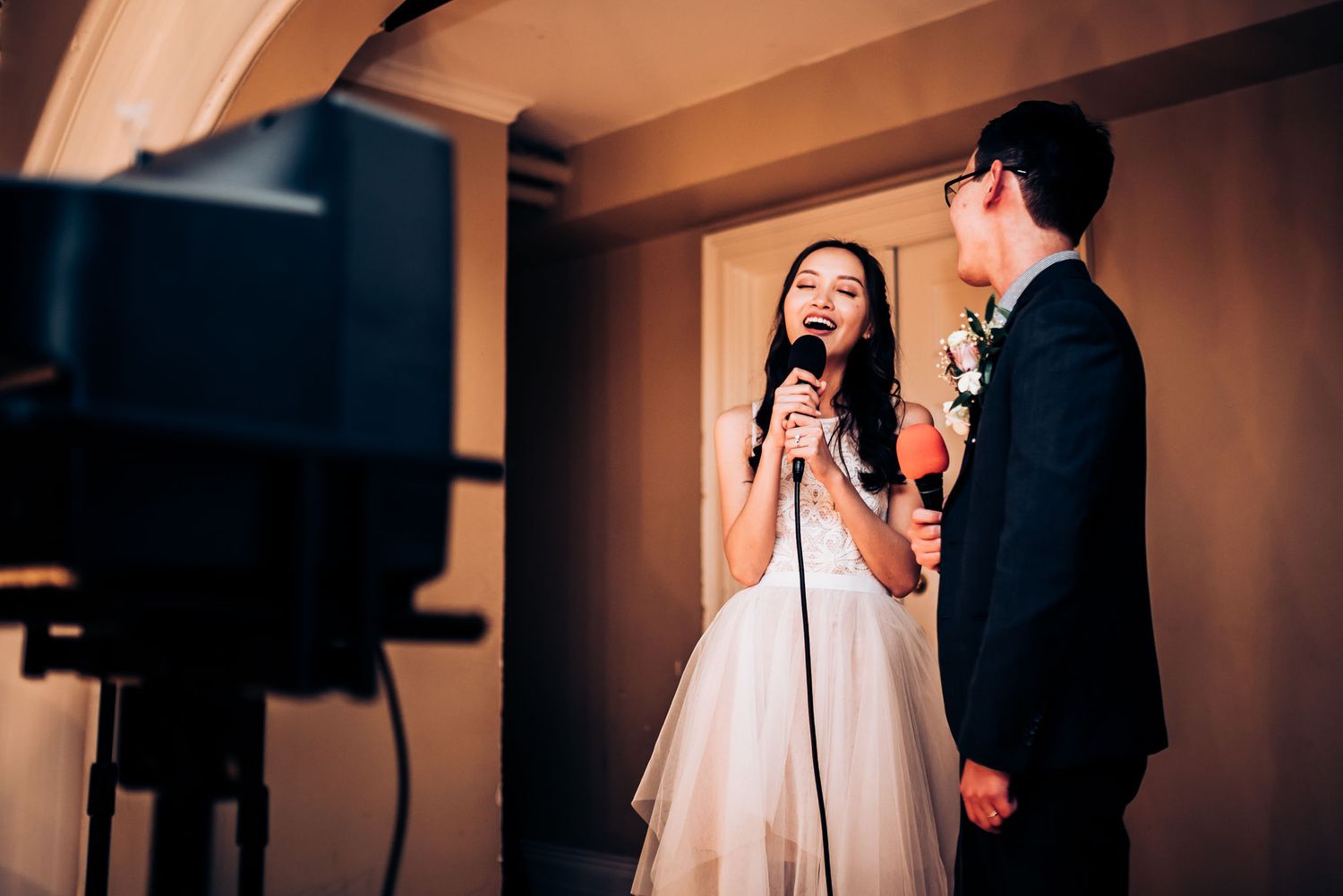 A couple performs karaoke during their wedding reception.