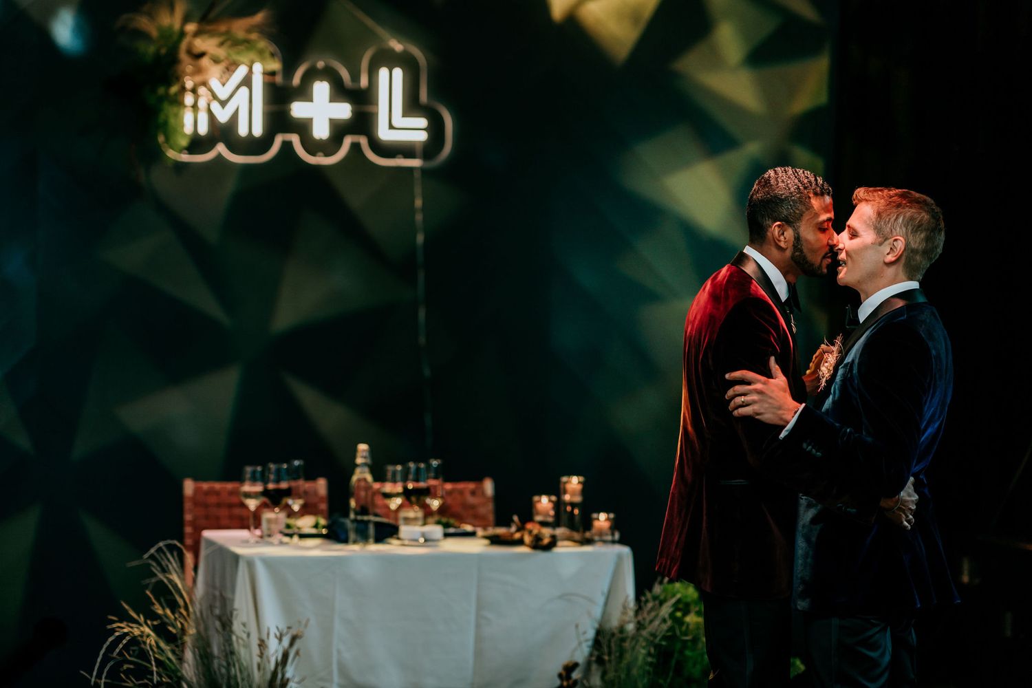 Romantic evening celebration with M+L sign glowing against geometric backdrop.