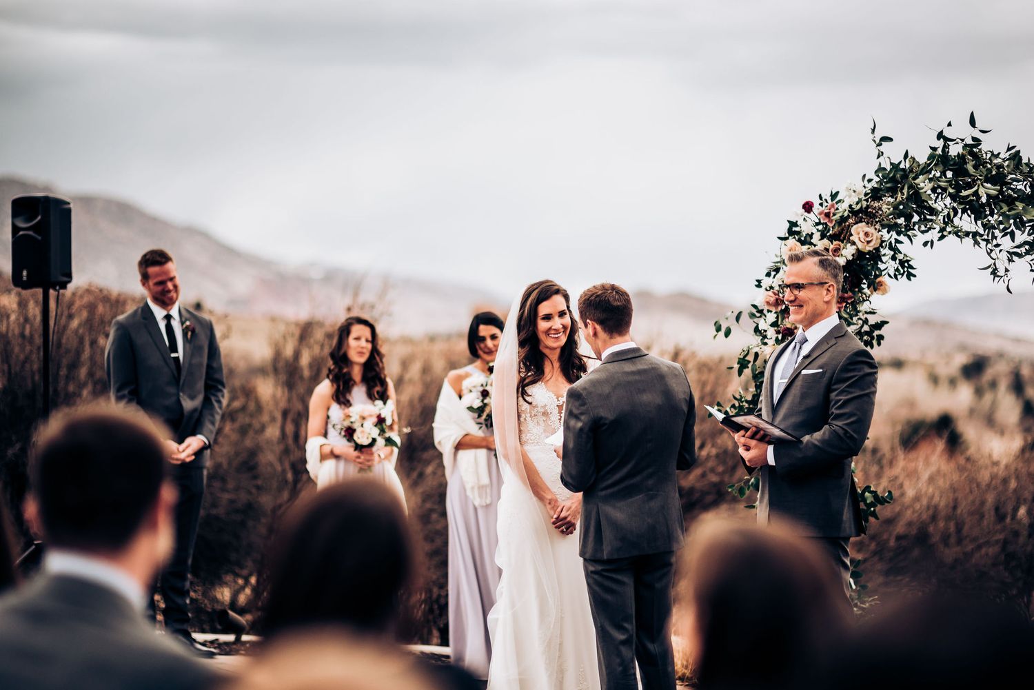 Wedding ceremony taking place outdoors with mountain views and natural landscape.