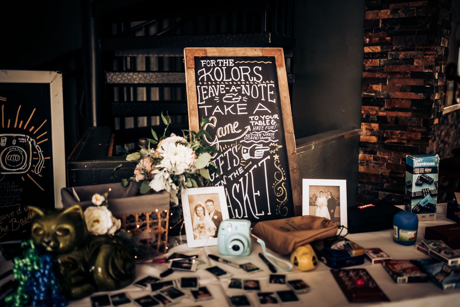 Rustic event setup with chalkboard signage, floral arrangements, and vintage decorations.