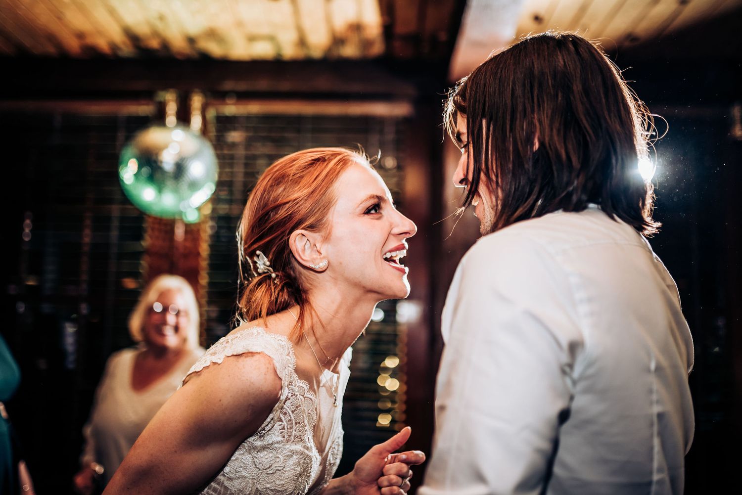 Two guests share a joyful moment dancing together under disco lights.