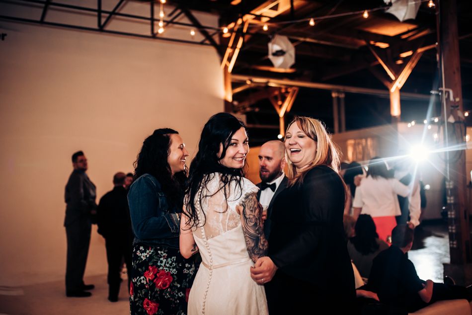 Wedding celebration with guests sharing a fun moment under warm lighting.