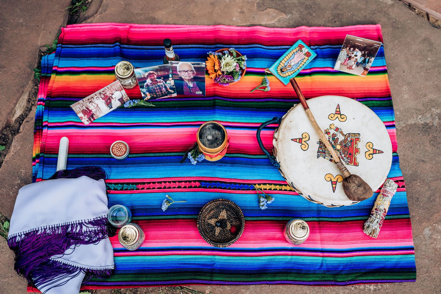 Colorful striped blanket with ceremonial items and decorative objects laid out for a wedding ritual.