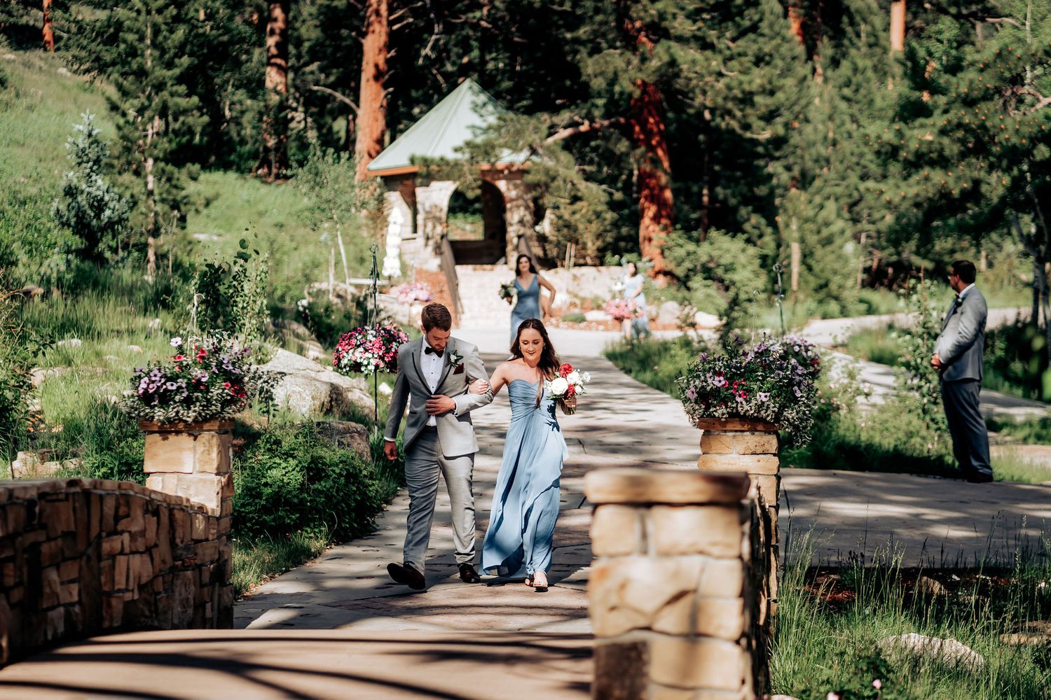Attendants rushing down a decorative stone pathway with a gazebo in the background.