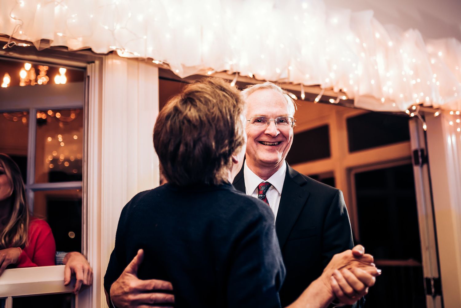 A joyful dance moment captured during a wedding reception with warm lighting.