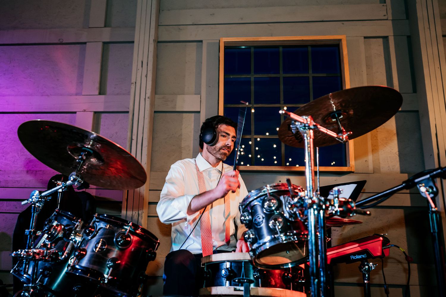 Drummer performs energetically behind a blue drum kit during a live music event.