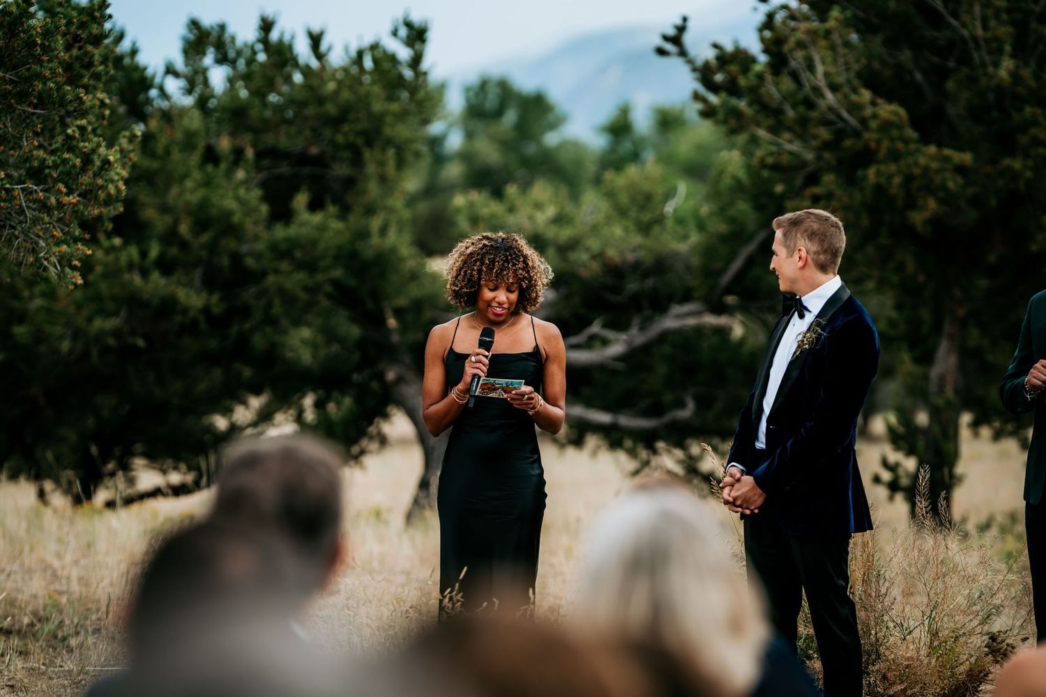Two people share an emotional moment during an outdoor wedding ceremony.