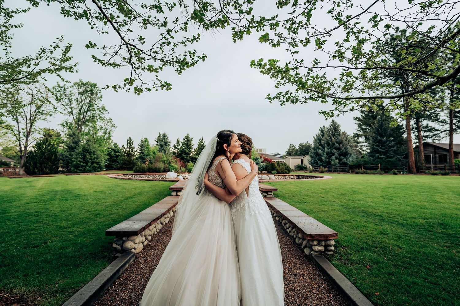 Beautiful wedding couple embracing on pathway with green landscape background.