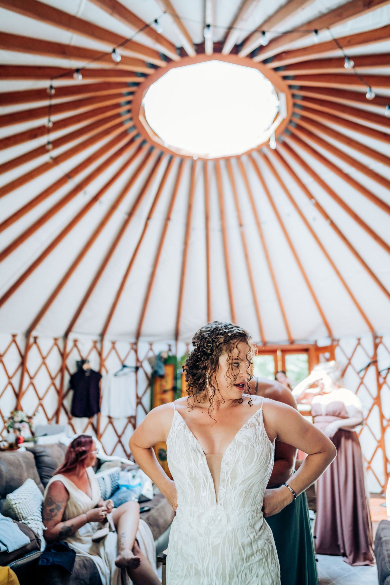 Interior of a yurt showing architectural details with wooden beams radiating from a central skylight.