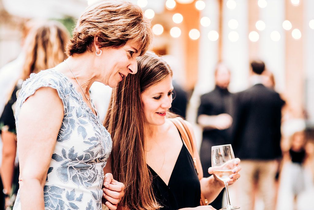 Two guests share a moment while enjoying drinks at an evening celebration.
