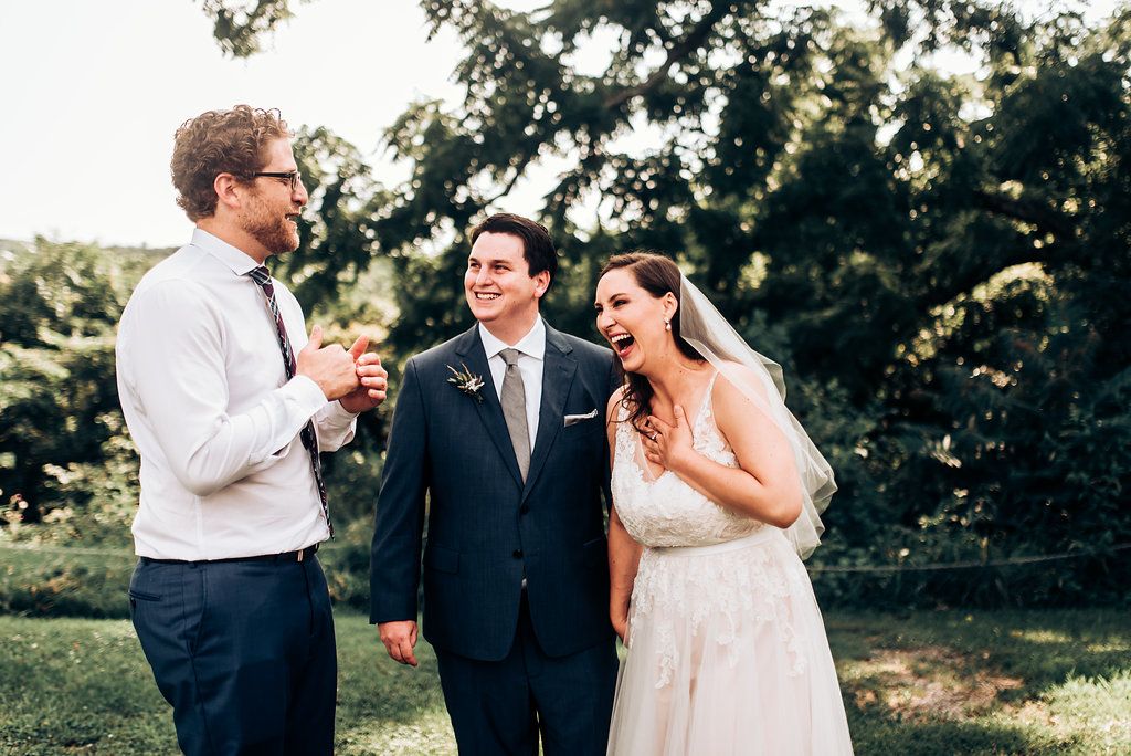Candid moment of laughter shared during outdoor wedding celebration.