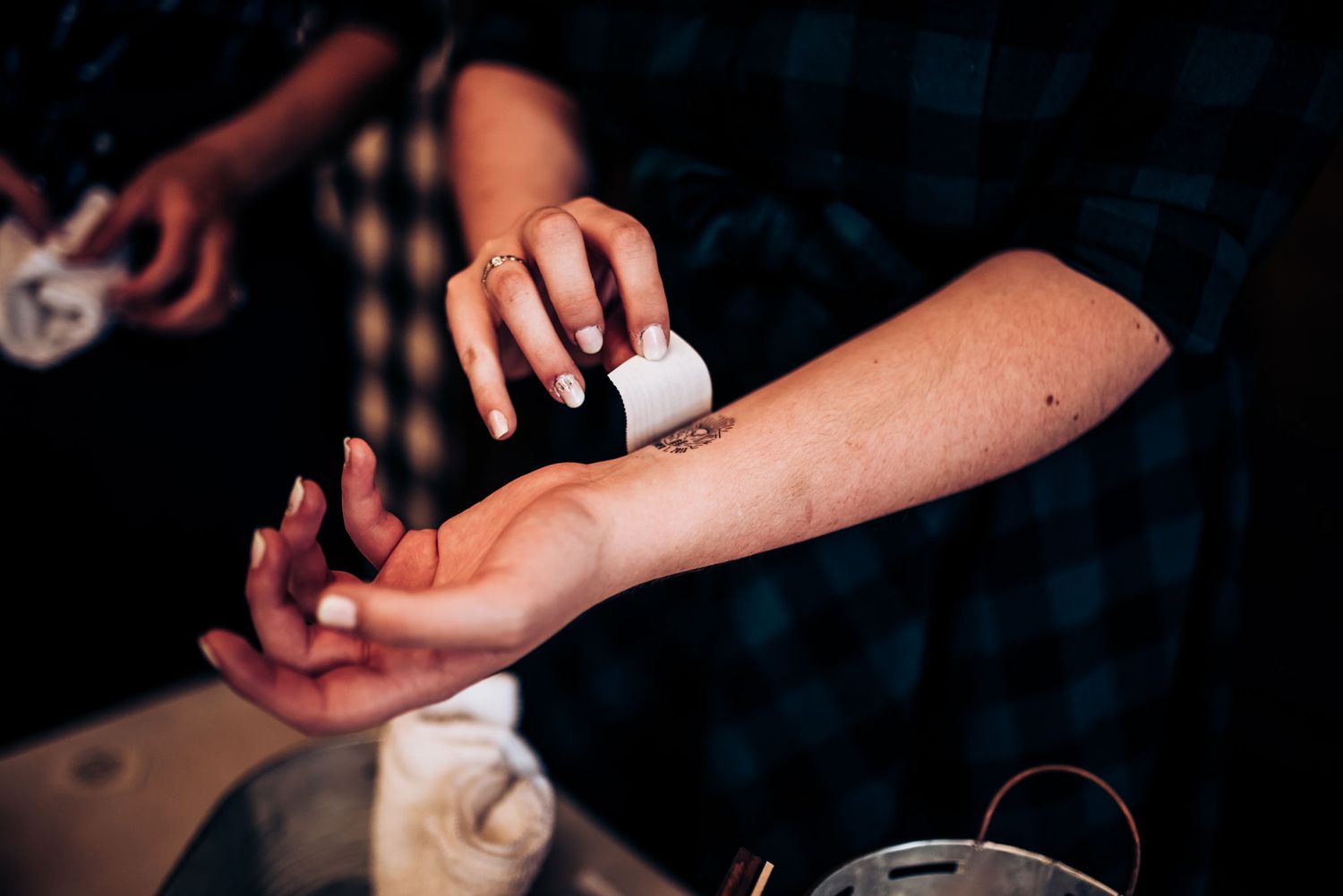Someone applying temporary art or henna to another person's forearm.