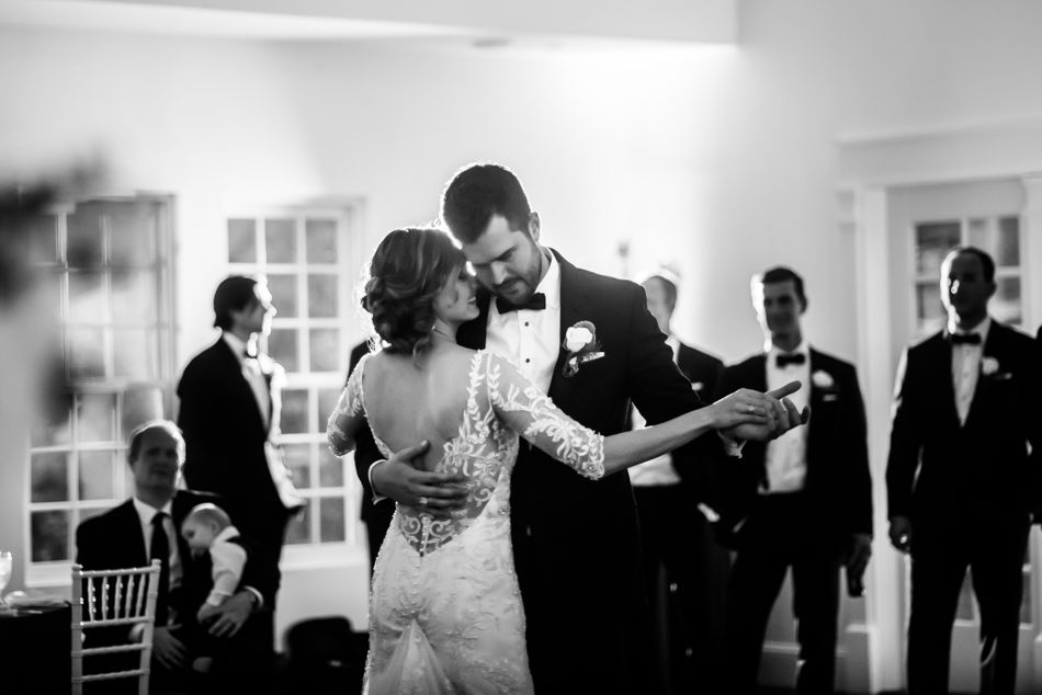 Intimate first dance moment captured in black and white at elegant wedding reception.